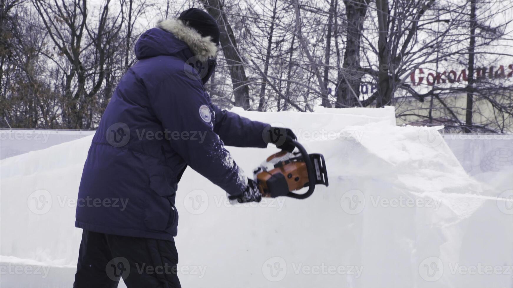 Man uses a chainsaw to efficiently clear heavy snow in winter photo