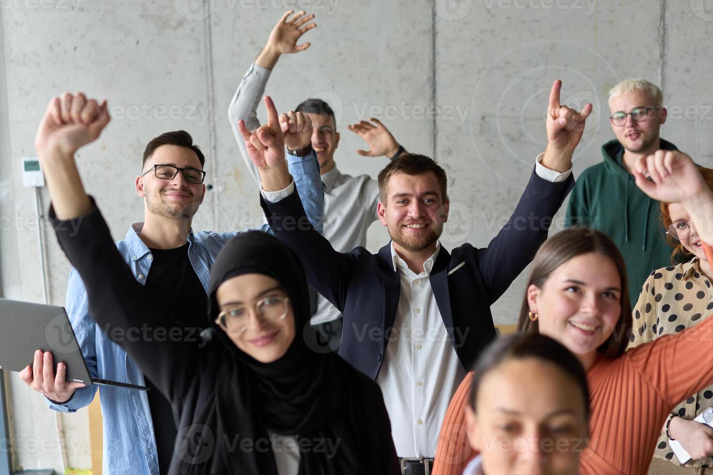 A diverse team of business professionals ecstatically celebrating their success in a modern office, expressing triumph and unity after achieving their goals photo