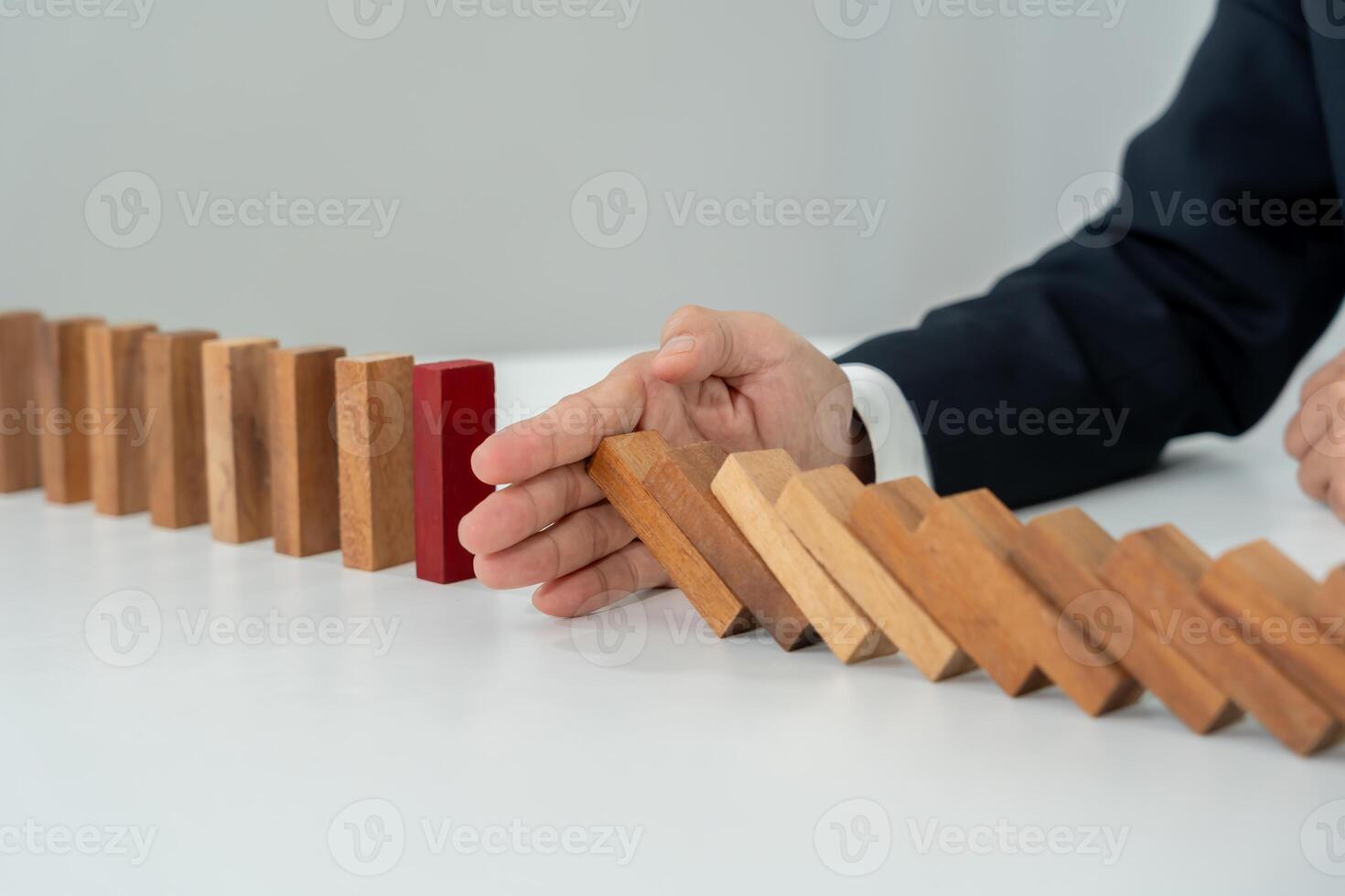 insurance with hands protect domino. Businessman hands stop dominoes falling in business crisis. business risk control and planning and strategies to run prevent insurance businesses. photo