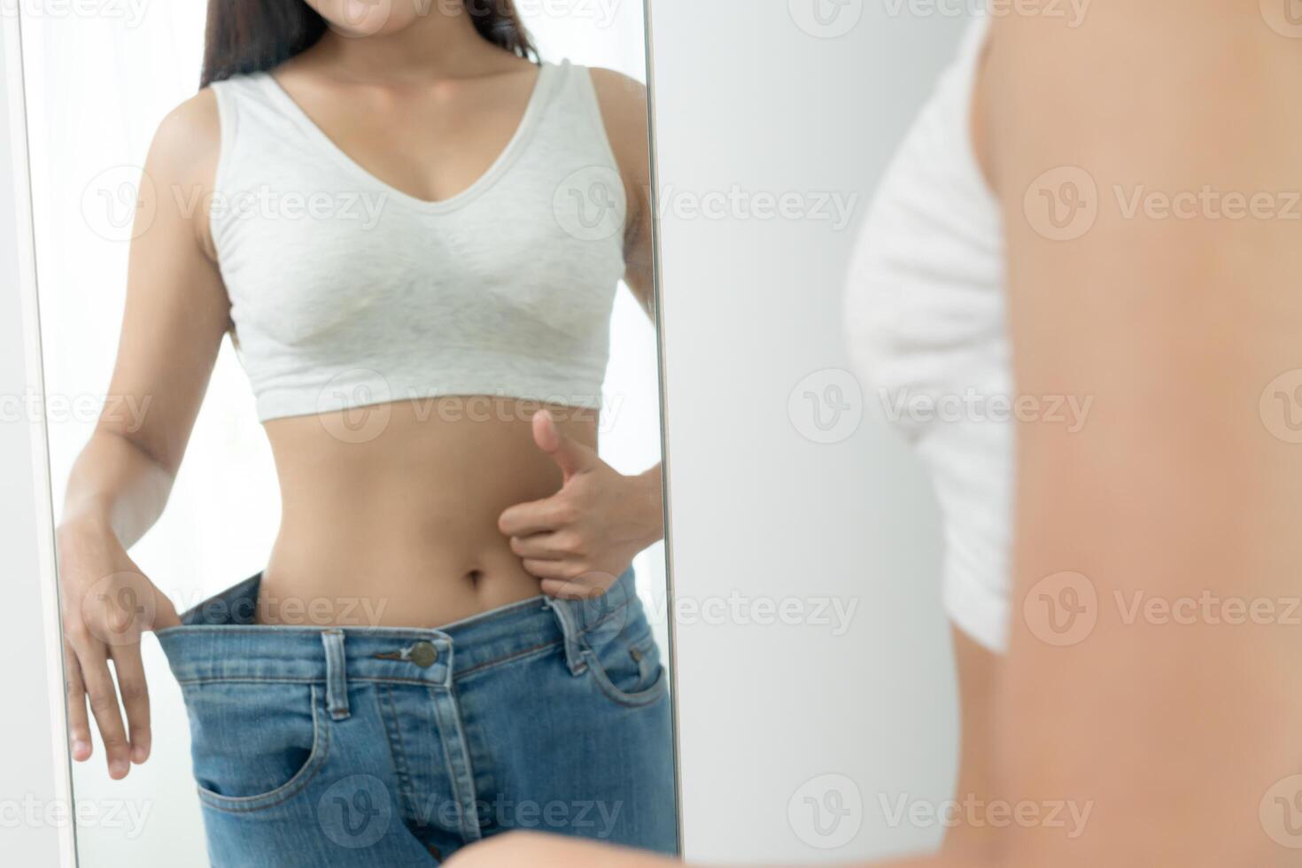 Women showing results of diet. Beautiful shape. female have a reduced waist size after under going a weight loss corse. can not wear jeans due to weight loss. balance, control, routines, exercise. photo