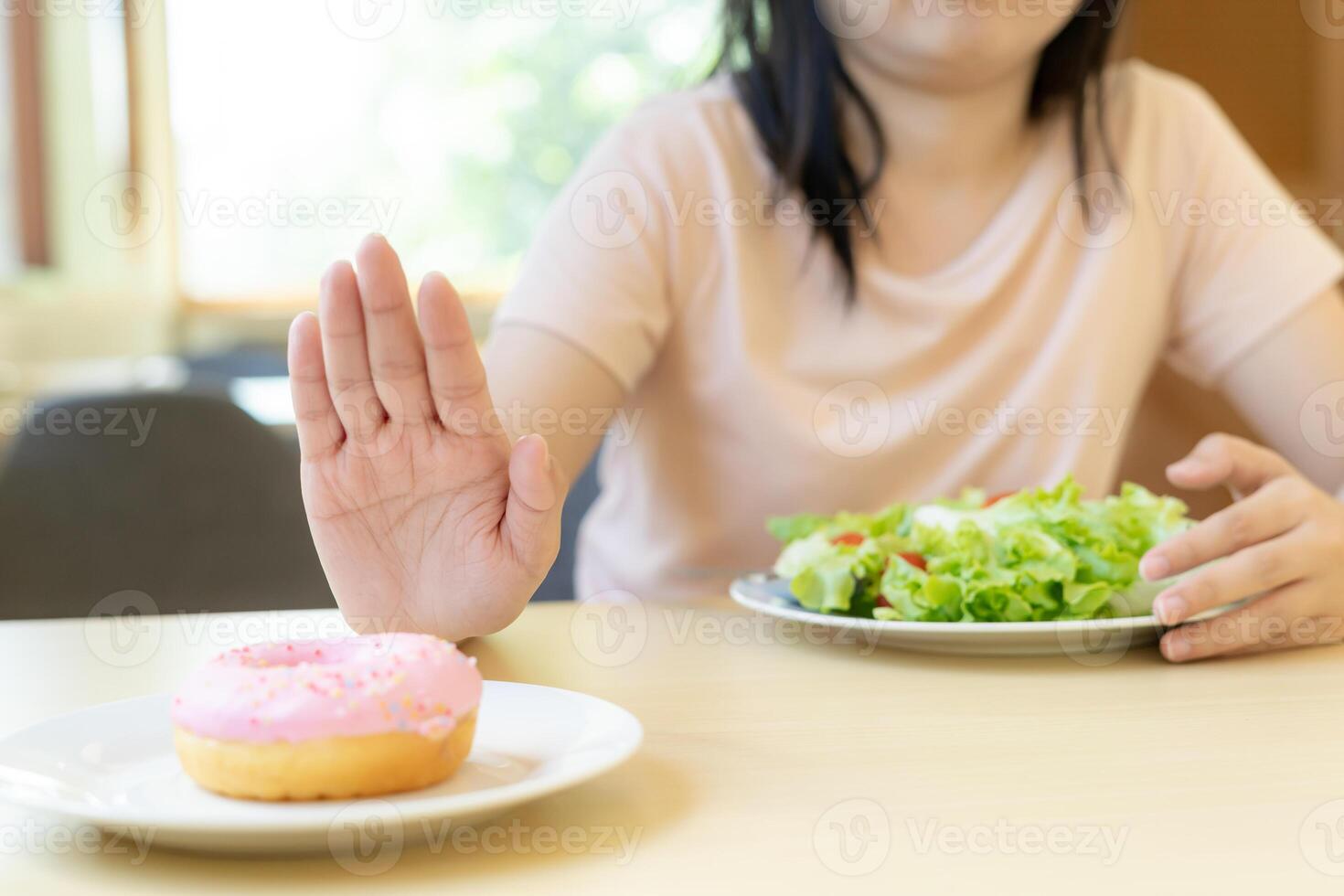 Diet and dieting. Beauty slim female body confuse donut. Woman in exercise clothes achieves weight loss goal for healthy life, crazy about thinness, thin waist, nutritionist. photo