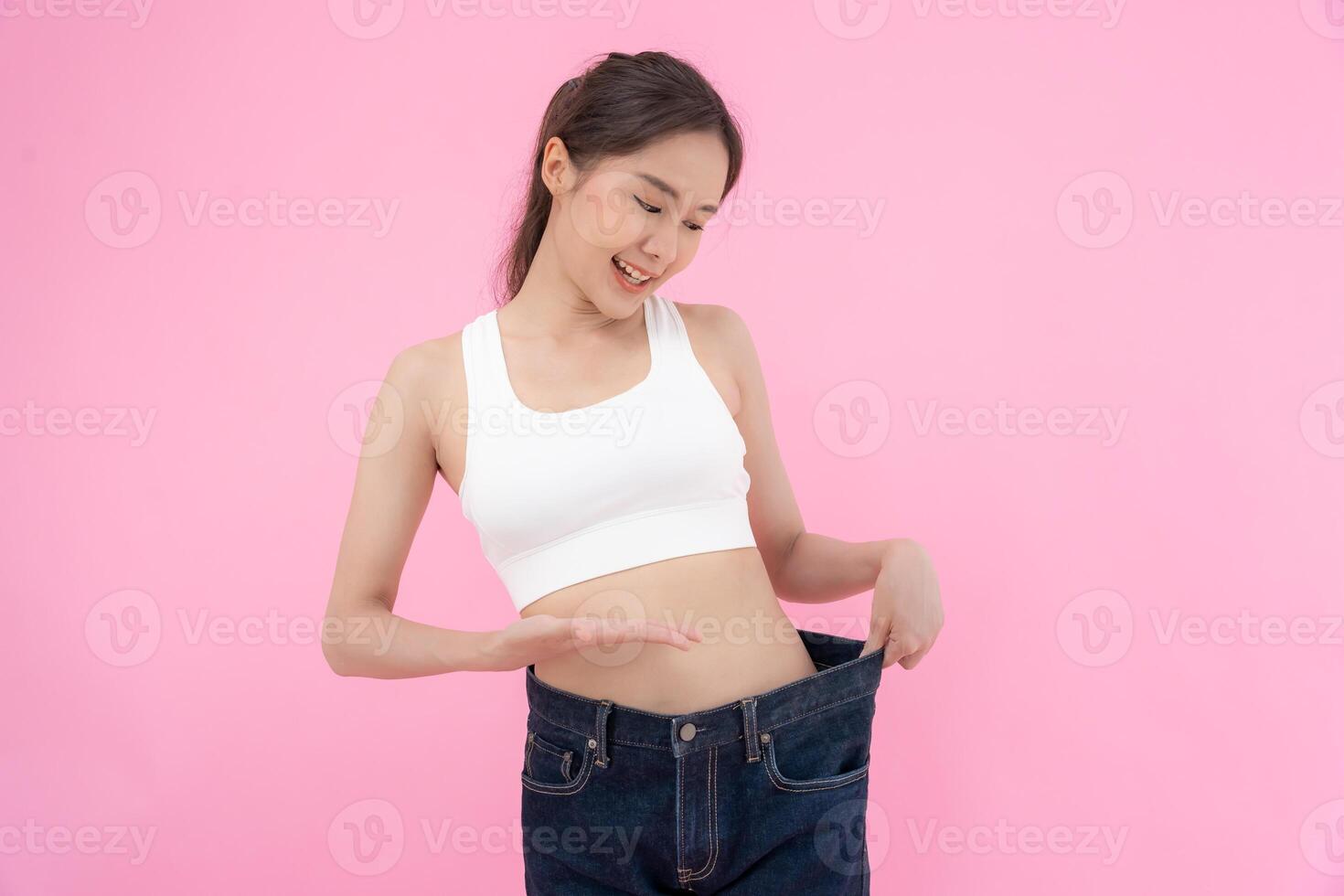 Women showing results of diet. Beautiful shape. female have a reduced waist size after under going a weight loss corse. can not wear jeans due to weight loss. balance, control, routines, exercise. photo