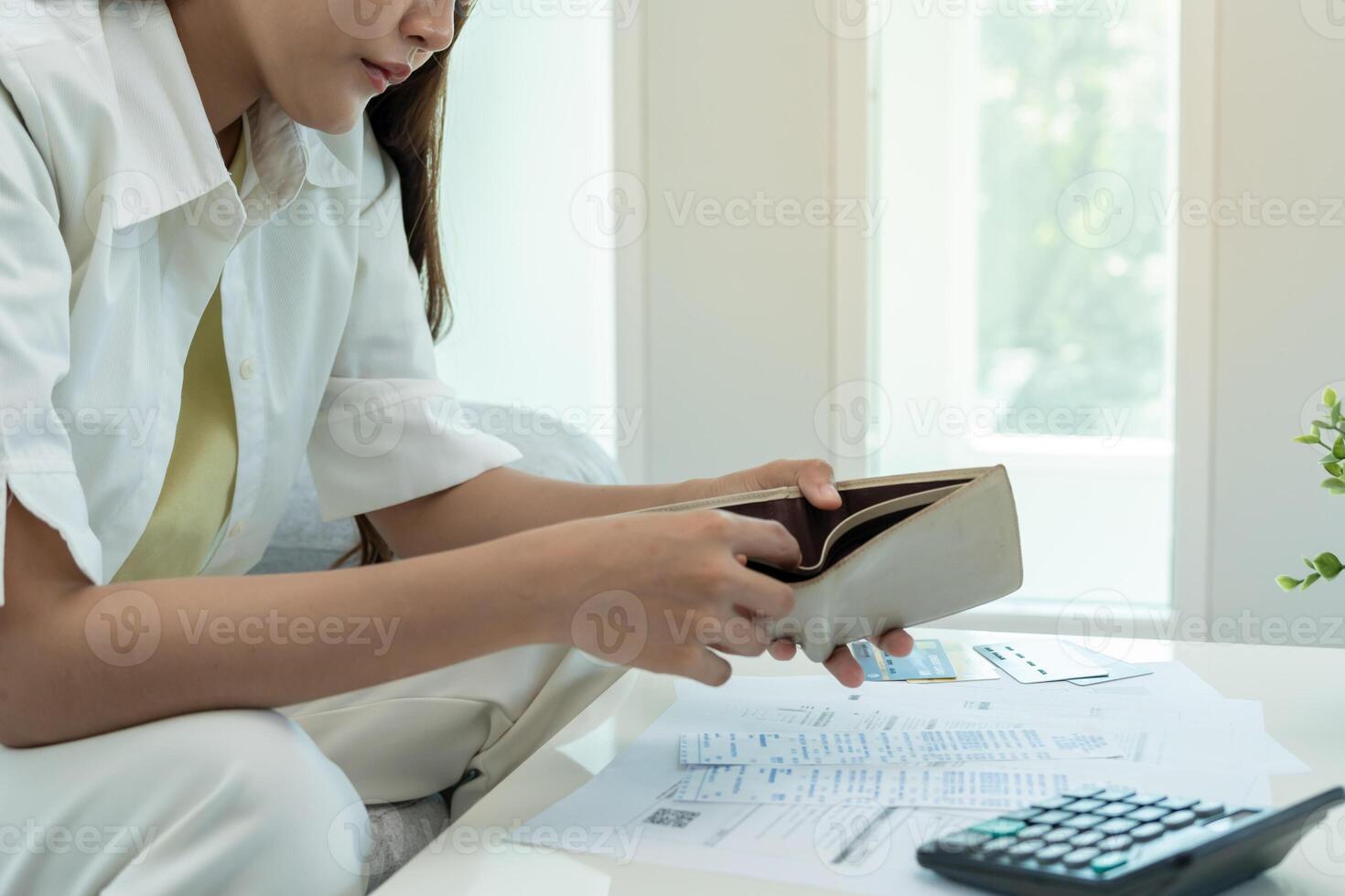 Stressed and headache asian woman with large bills or invoices no money to pay to expenses and credit card debt. shortage, Financial problems, mortgage, loan, bankruptcy, bankrupt, poor, empty wallet photo