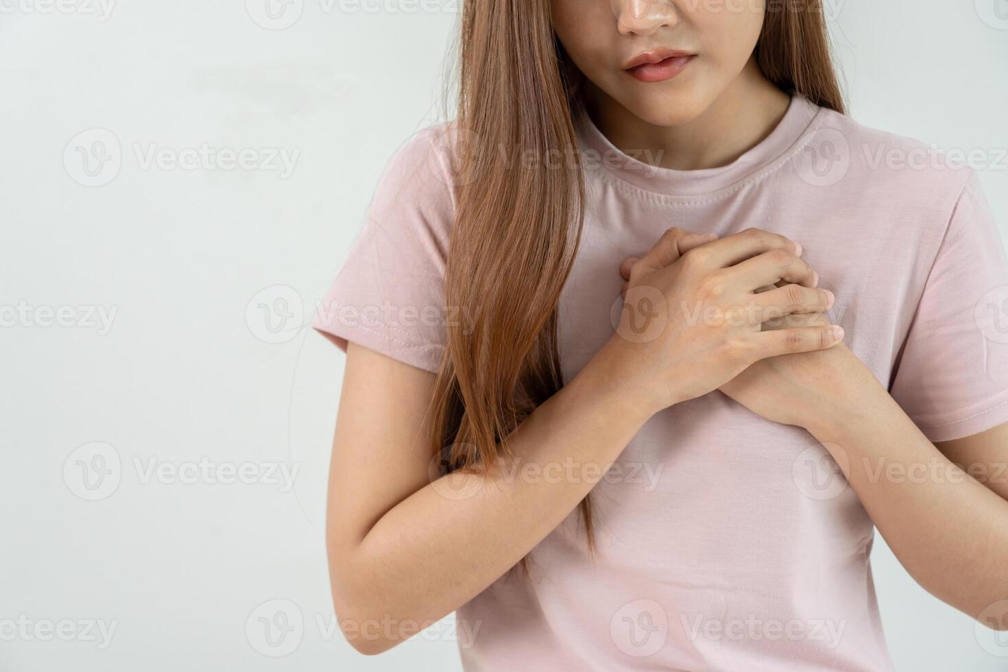 hand hold chest with heart attack symptoms, asian woman have chest pain caused by heart disease, leak, dilatation, enlarged coronary heart, press on the chest with a painful expression photo