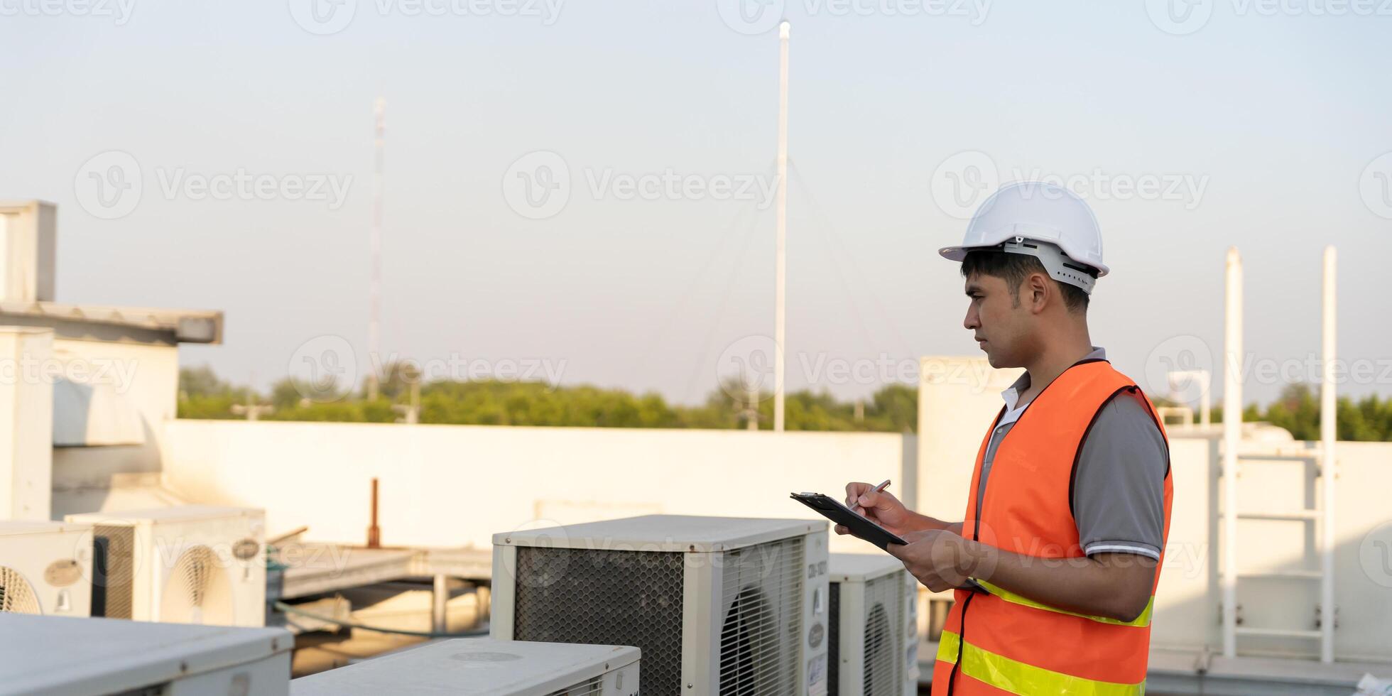 Asian maintenance engineer works on the roof of factory. contractor inspect compressor system and plans installation of air condition systems in construction. Checklist, inspector, control photo