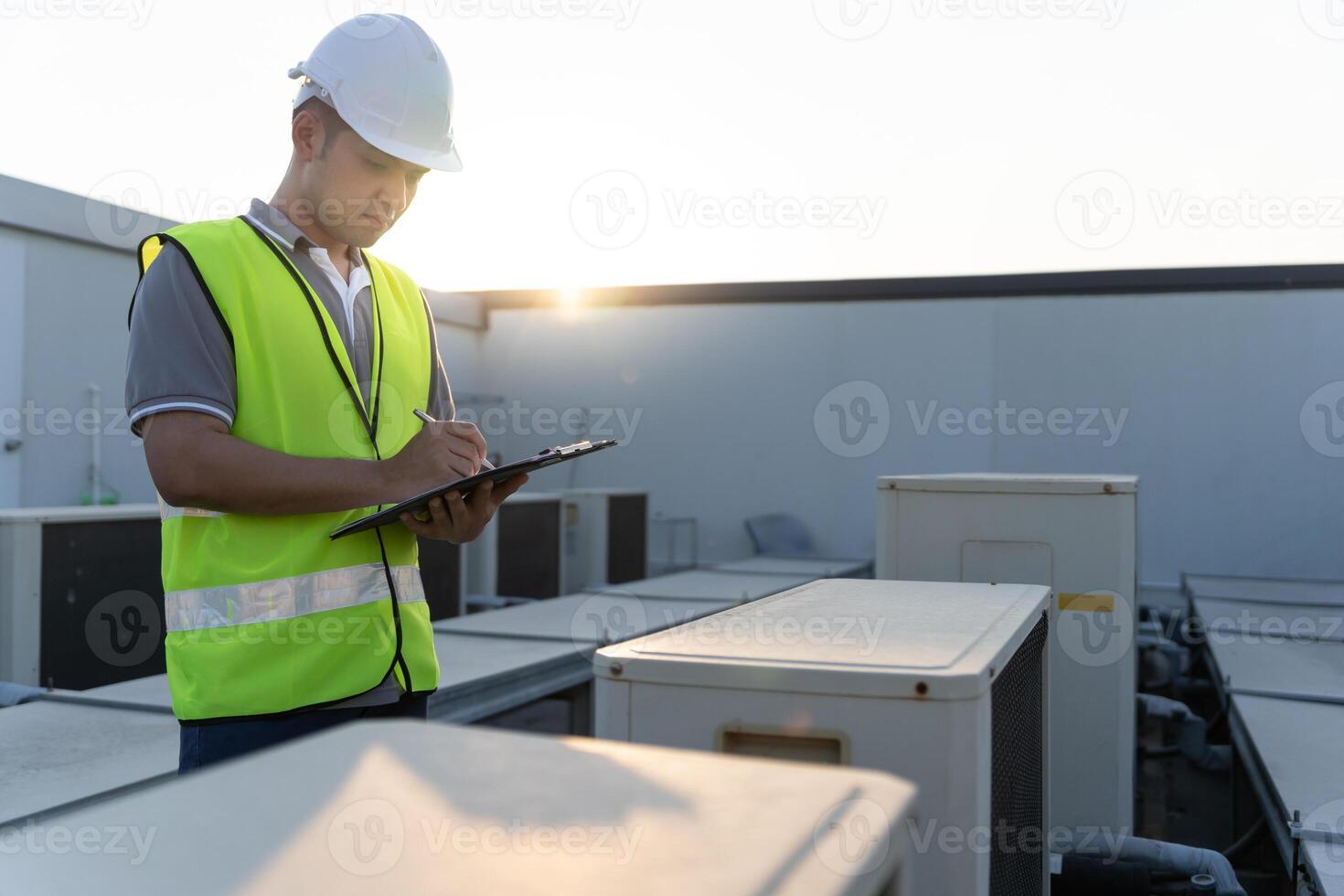 Portrait Asian maintenance engineer works on the roof of factory. contractor inspect compressor system and plans installation of air condition systems in construction, inspector, control photo