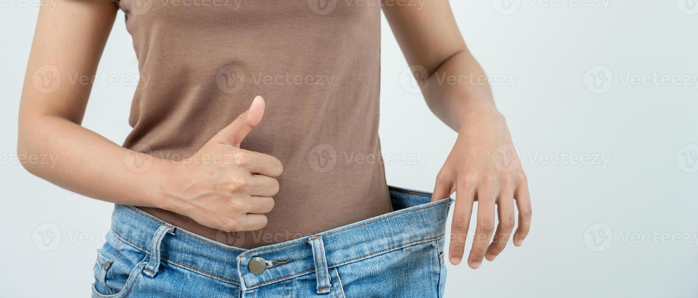 women happy results of diet. Beautiful shape. female have a reduced waist size after under going a weight loss corse. can not wear jean due to weight loss. balance, control, routines, exercise. photo
