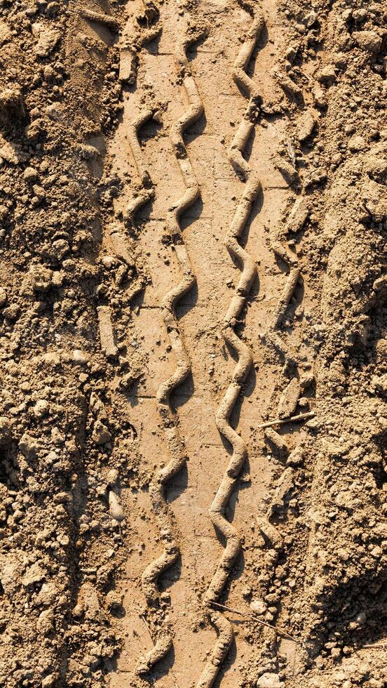 A close up of a tire track in the dirt photo