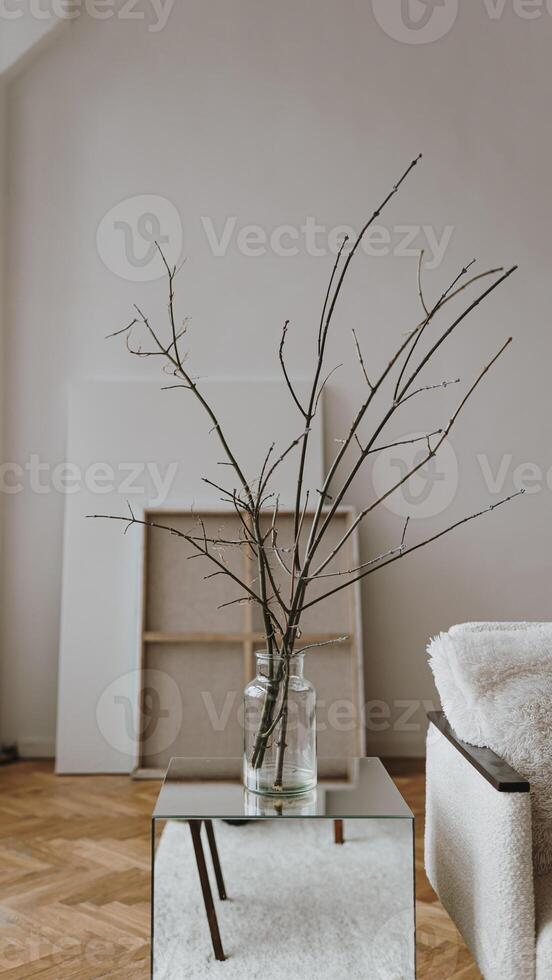 A vase with branches in it sitting on a table photo