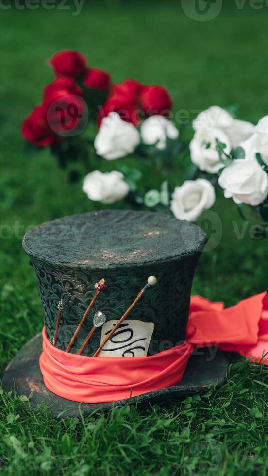 A hat with red ribbon and flowers on the grass photo