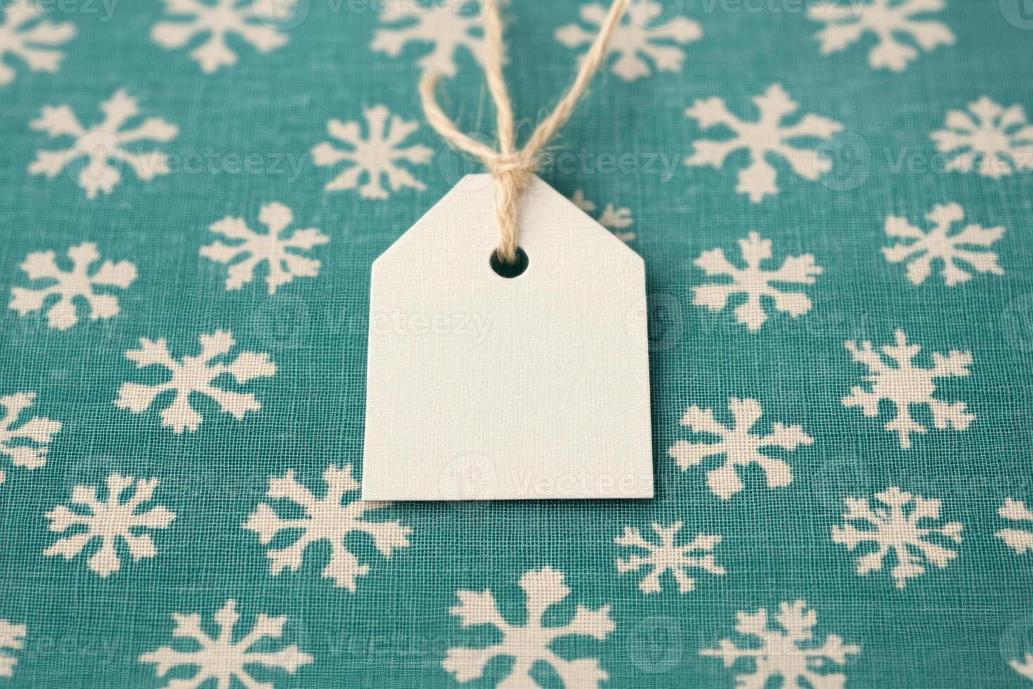 Blank gift tag on a teal snowflake background, ideal for seasonal decoration. photo
