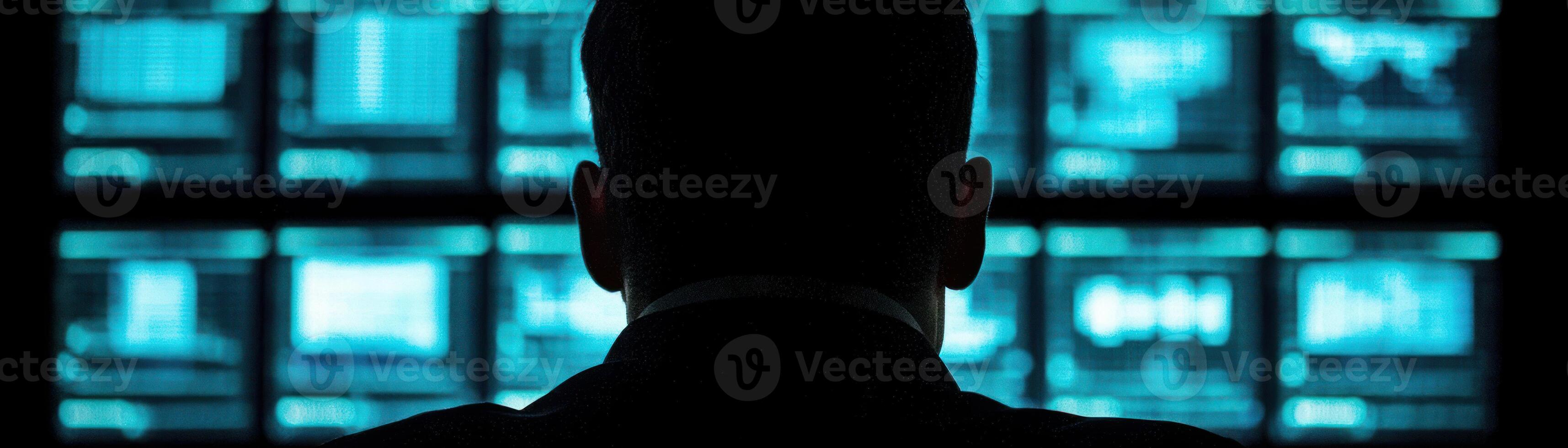 A person monitors multiple screens, representing data analysis and technological oversight. photo