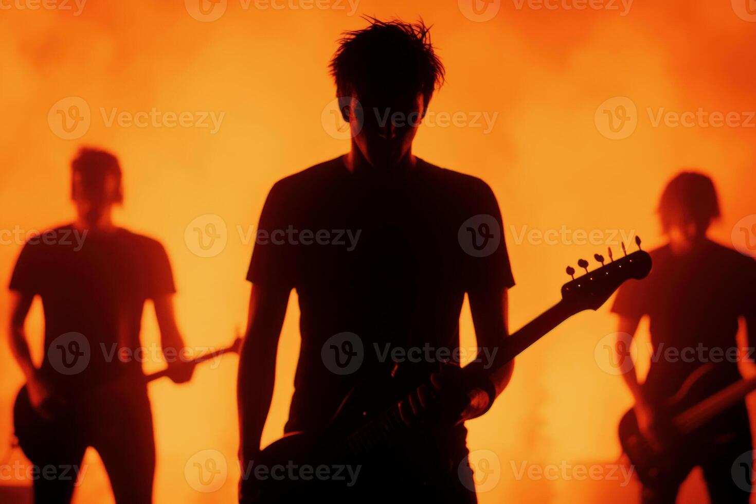 Silhouetted musicians perform passionately against a fiery backdrop. photo