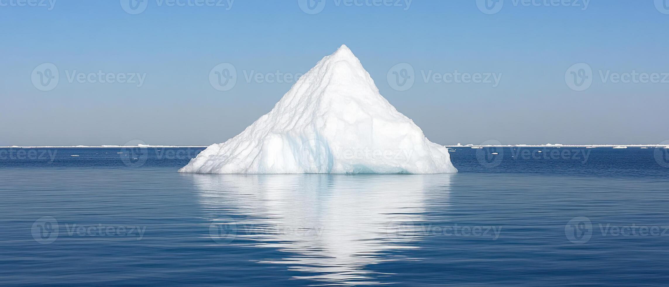 A stunning iceberg stands majestically in calm blue waters under a clear sky. photo