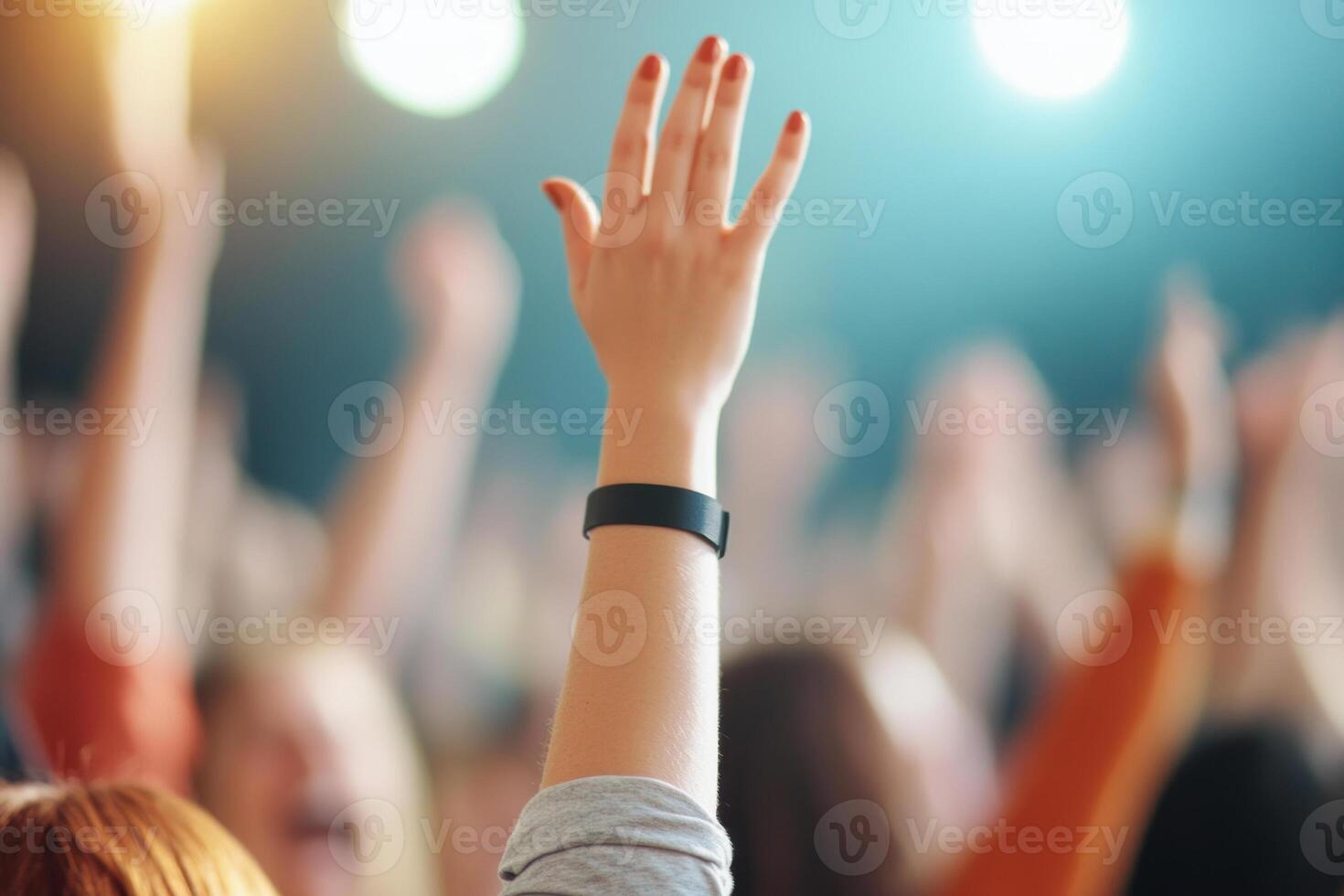 Hands raised in excitement at a lively concert or event, showcasing joy and engagement. photo