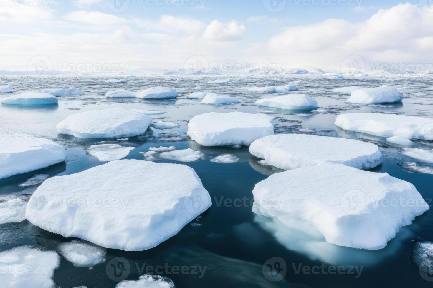 Icebergs floating in serene waters under a bright, cloudy sky reflect nature's beauty. photo
