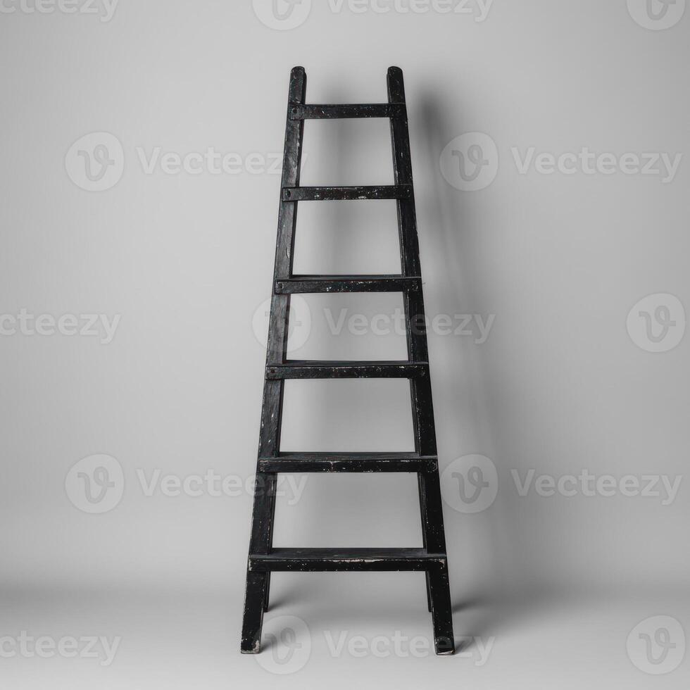 A simple black wooden ladder against a plain background. photo