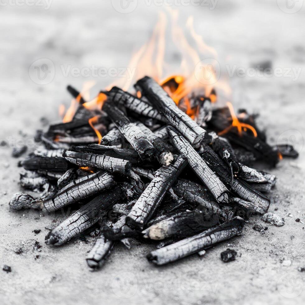 Burning charcoal with glowing embers and smoke on a surface. photo