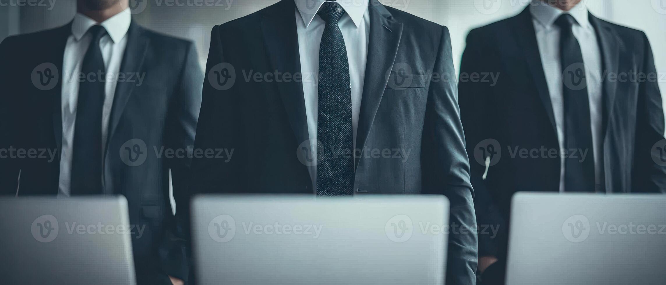 Three professionals in suits collaborating in a modern office setting. photo