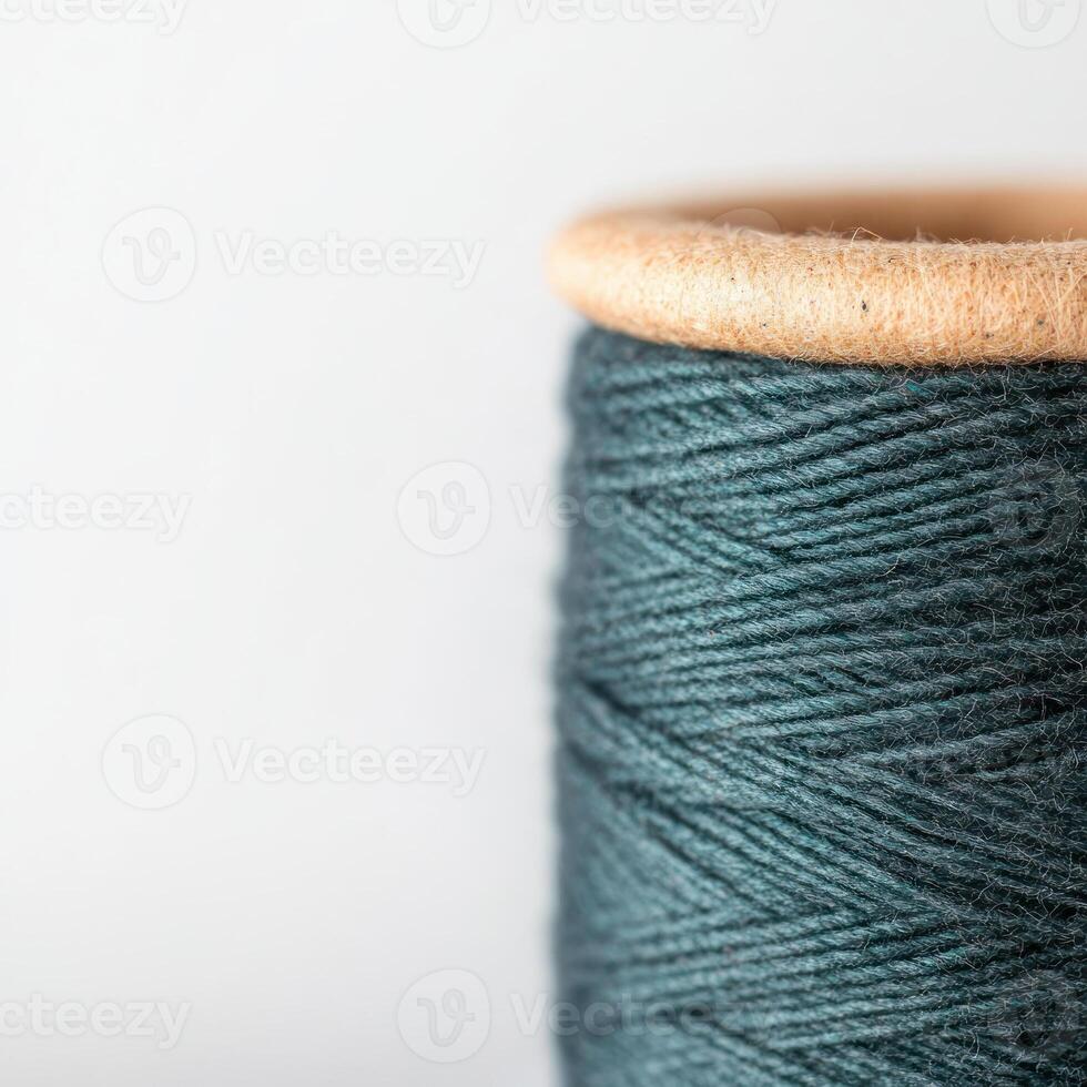 Close-up of a teal sewing thread on a wooden spool. isolated on white background. photo