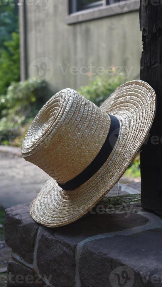 A straw hat is sitting on a stone wall photo