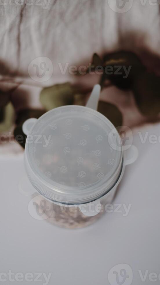 A plastic container with a lid on top of a white table photo