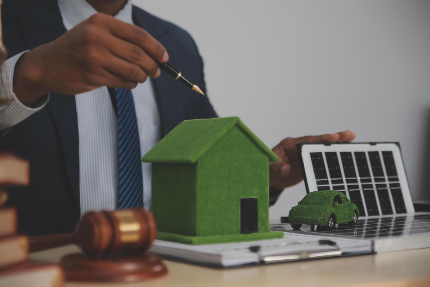 Auctioneer knocks down property sale by sample house and lawyer's gavel, judge mediates in property dispute in court car judge's gavel on wooden background Buying and selling real estate, housing photo