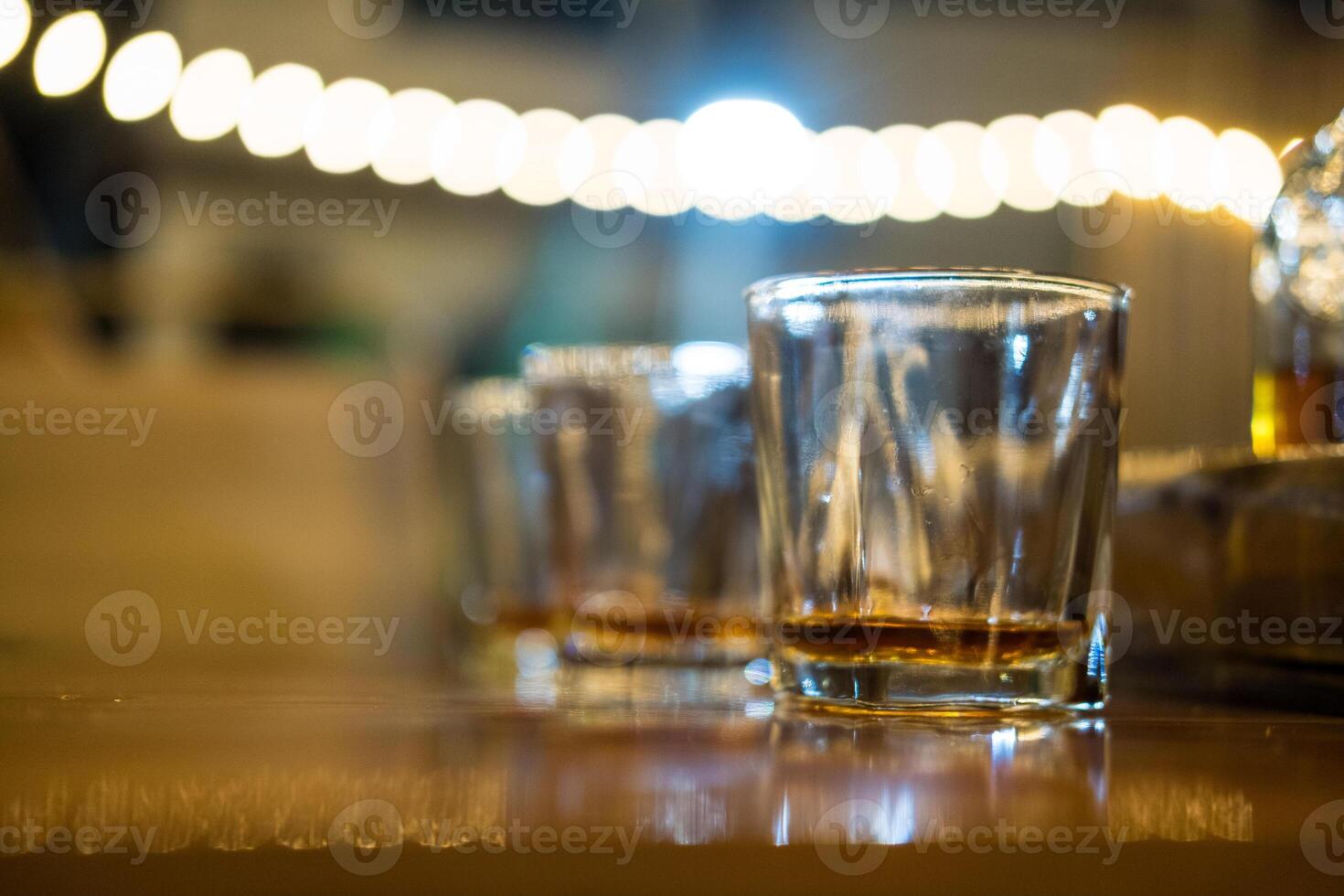 Vodka in shot glasses with a bokeh background. photo