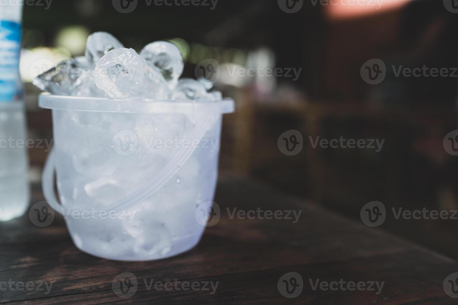 Full of ice cubes in transparent plastic bucket photo