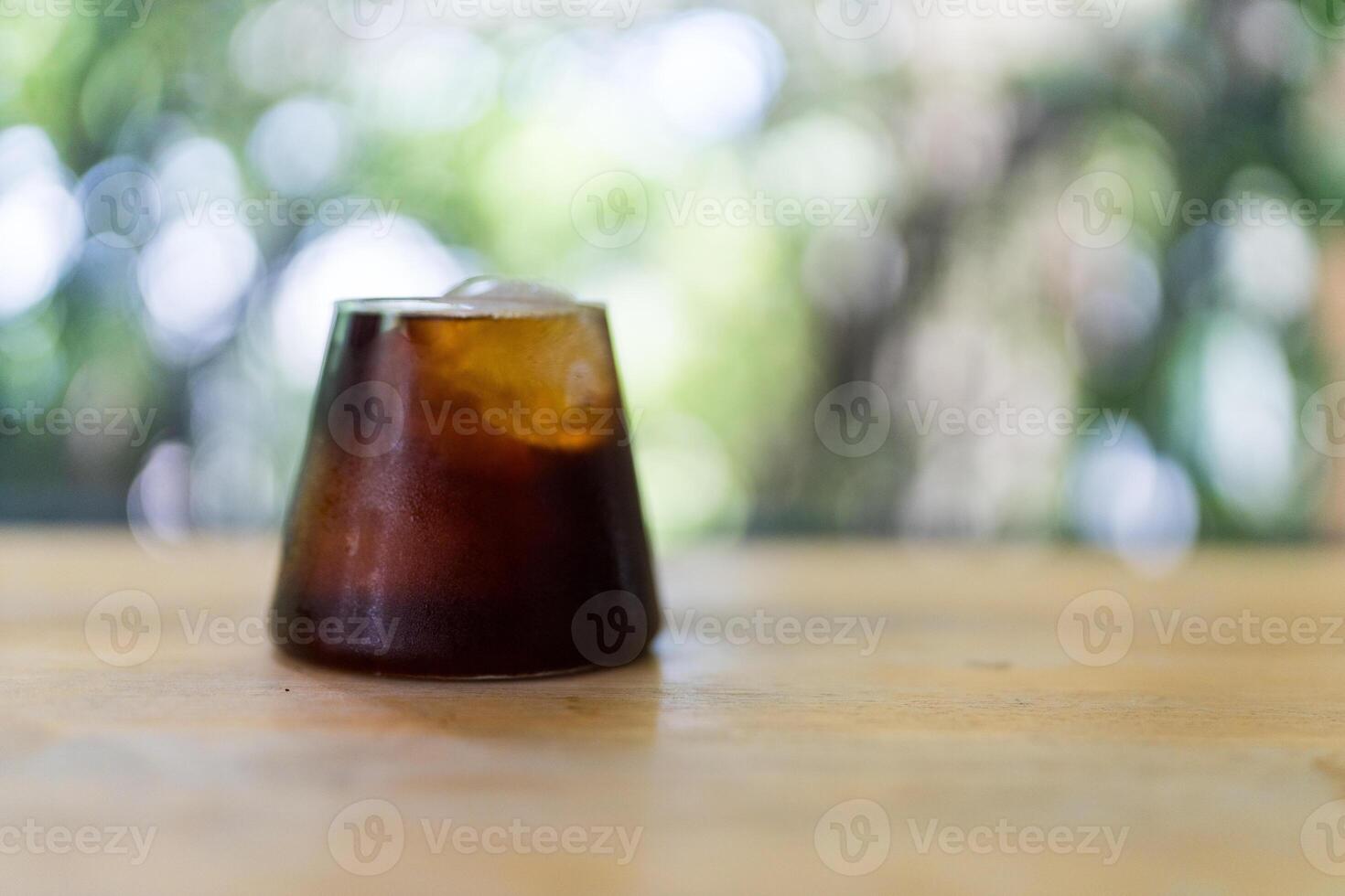 Close up of a black coffee with ice cubes in a clear glass photo