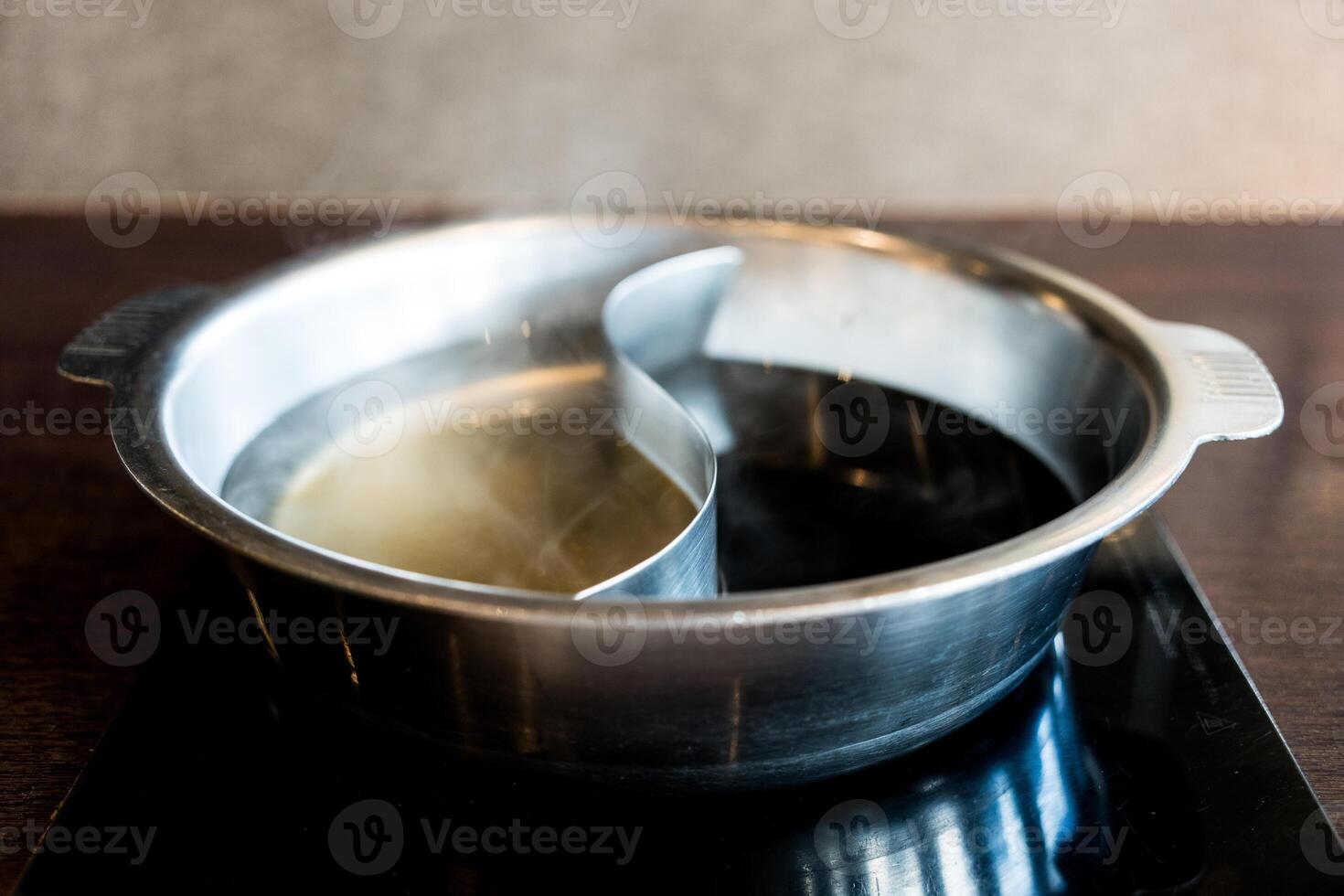 Hot pot three ways soup including original herb clear soup and black Sukiyaki soup. photo