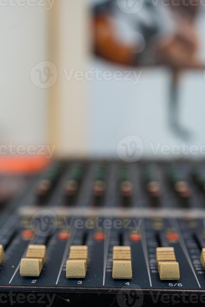 Amplifying equipment adjusts studio audio mixer knobs and faders. photo