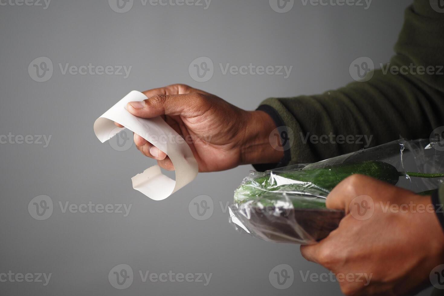 Close-Up of Hands Holding Receipt and Grocery Packet photo