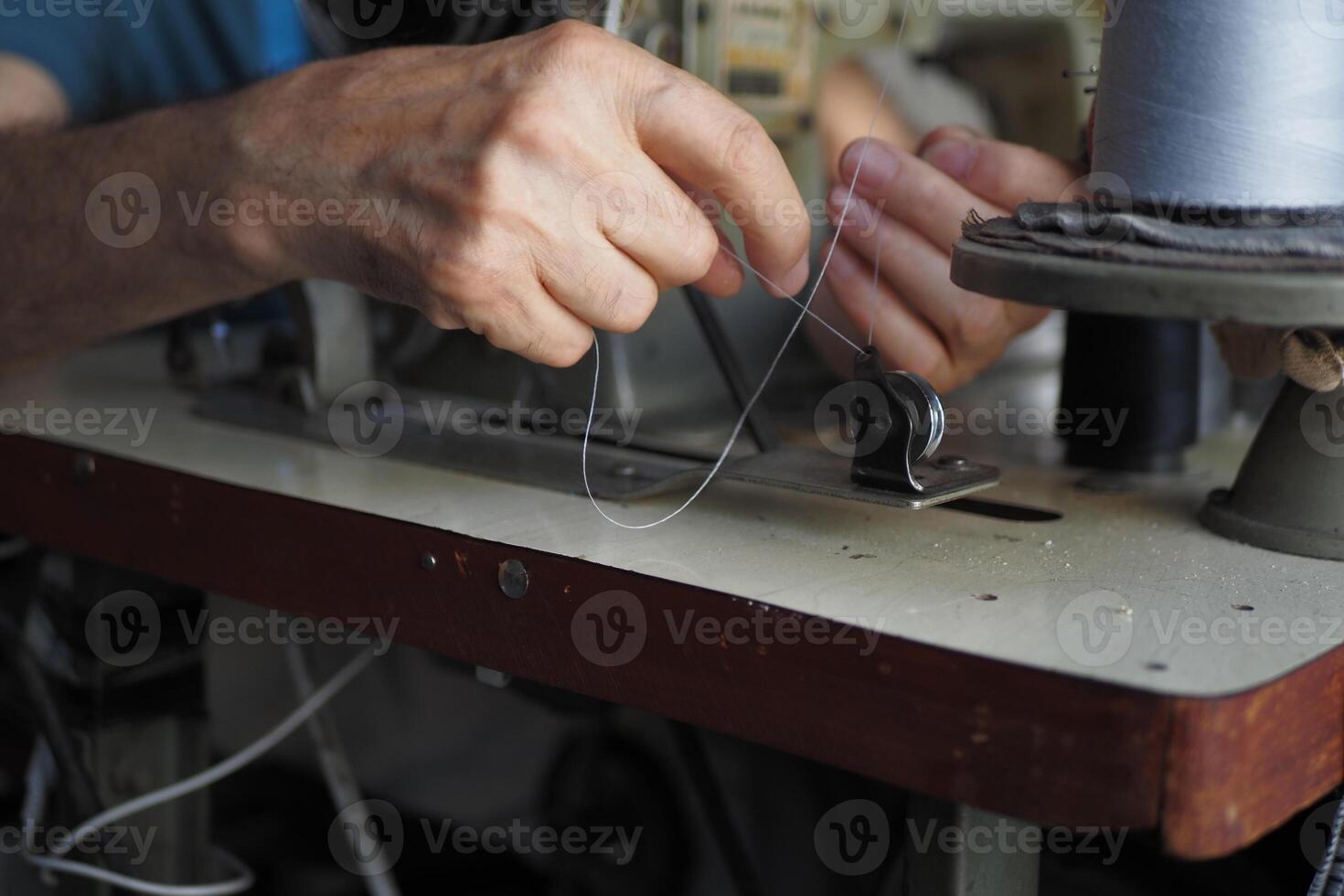 A closeup view of hands skillfully using a sewing machine for tailoring photo