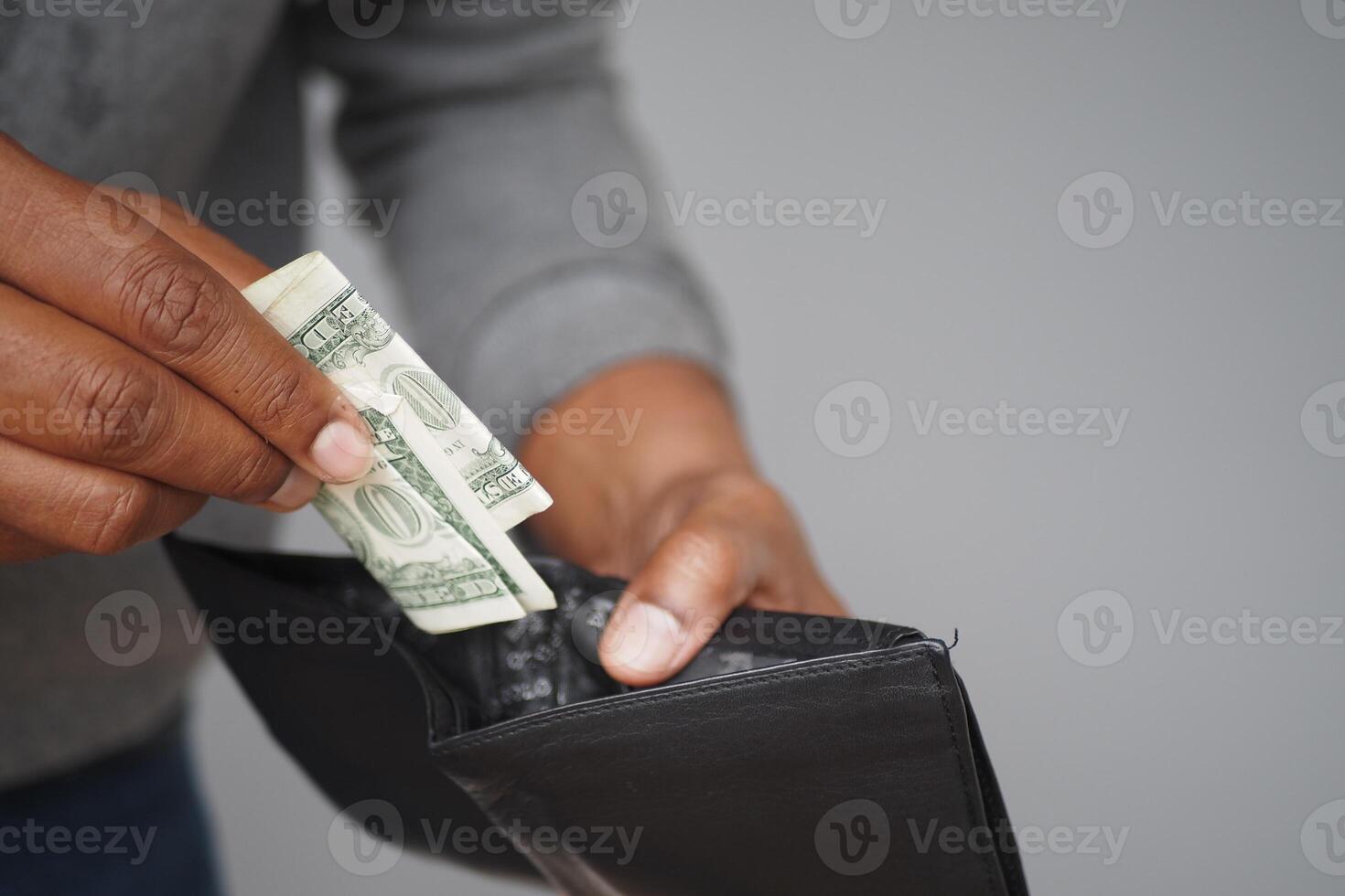 Utilizing Cash Carefully Hand Inserting a Dollar Bill into Wallet Space photo