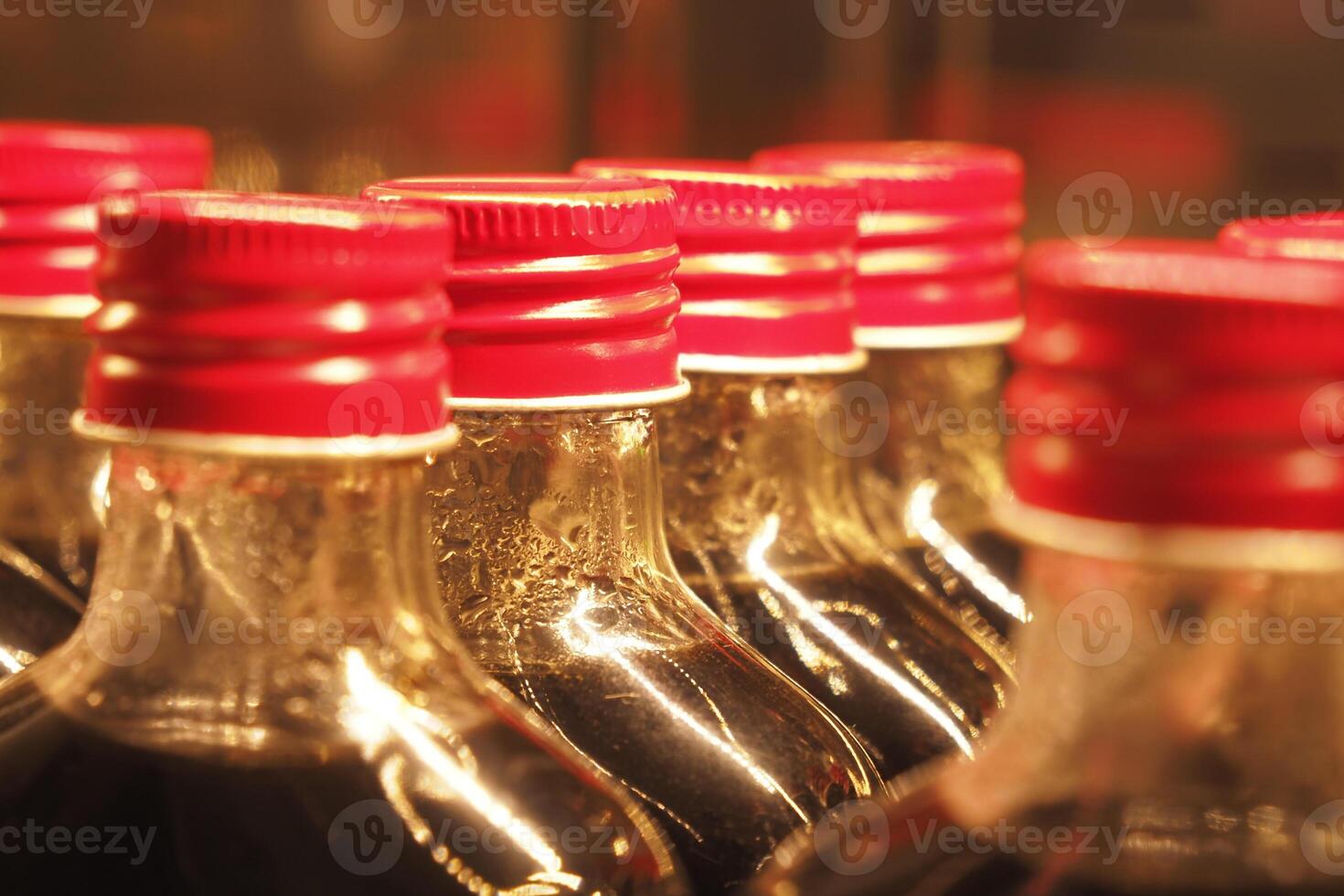 A closeup view featuring bottles that have bright red caps on them photo