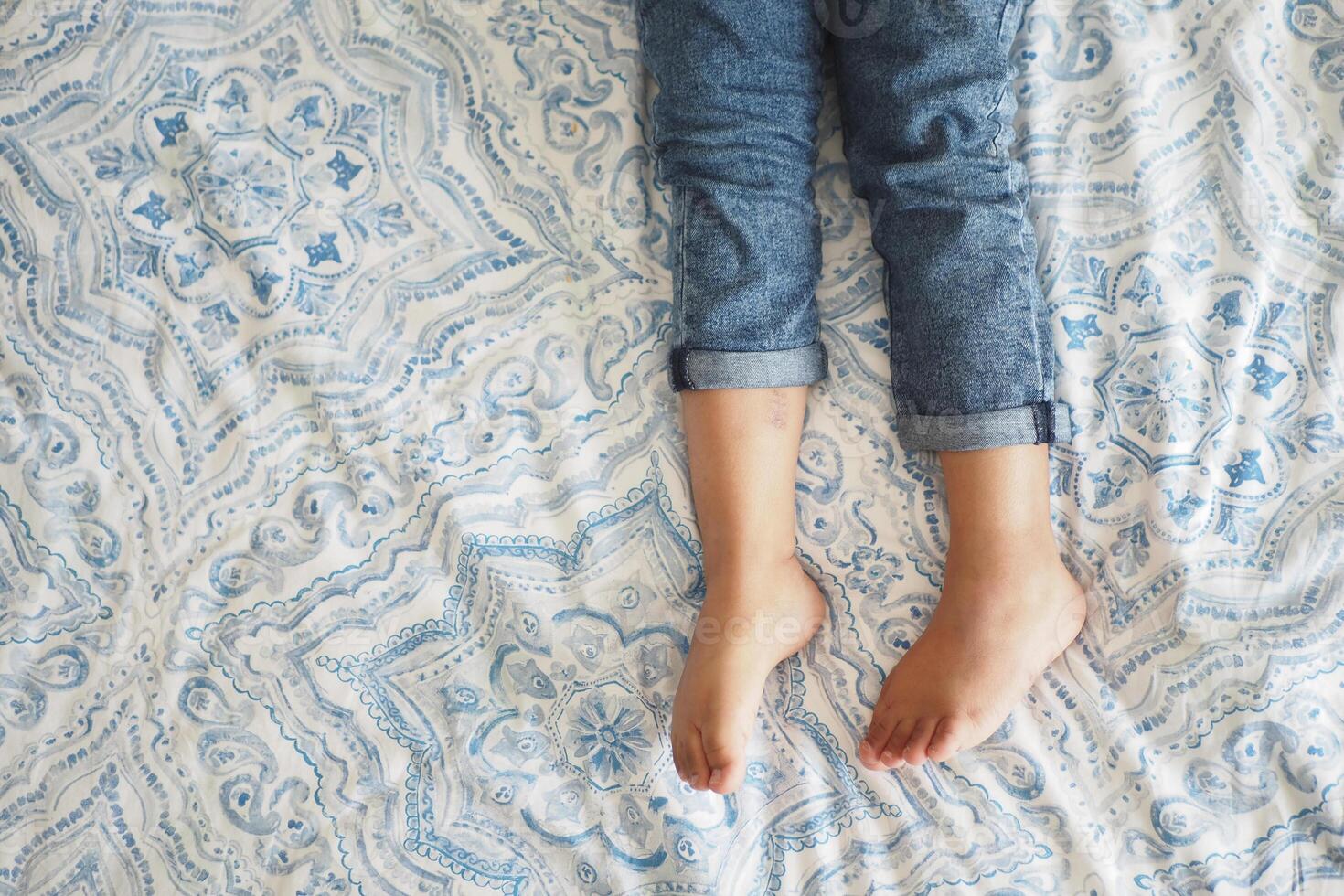 Relaxing Your Bare Feet on a Cozy Bedspread in Soft Soothing Colors photo