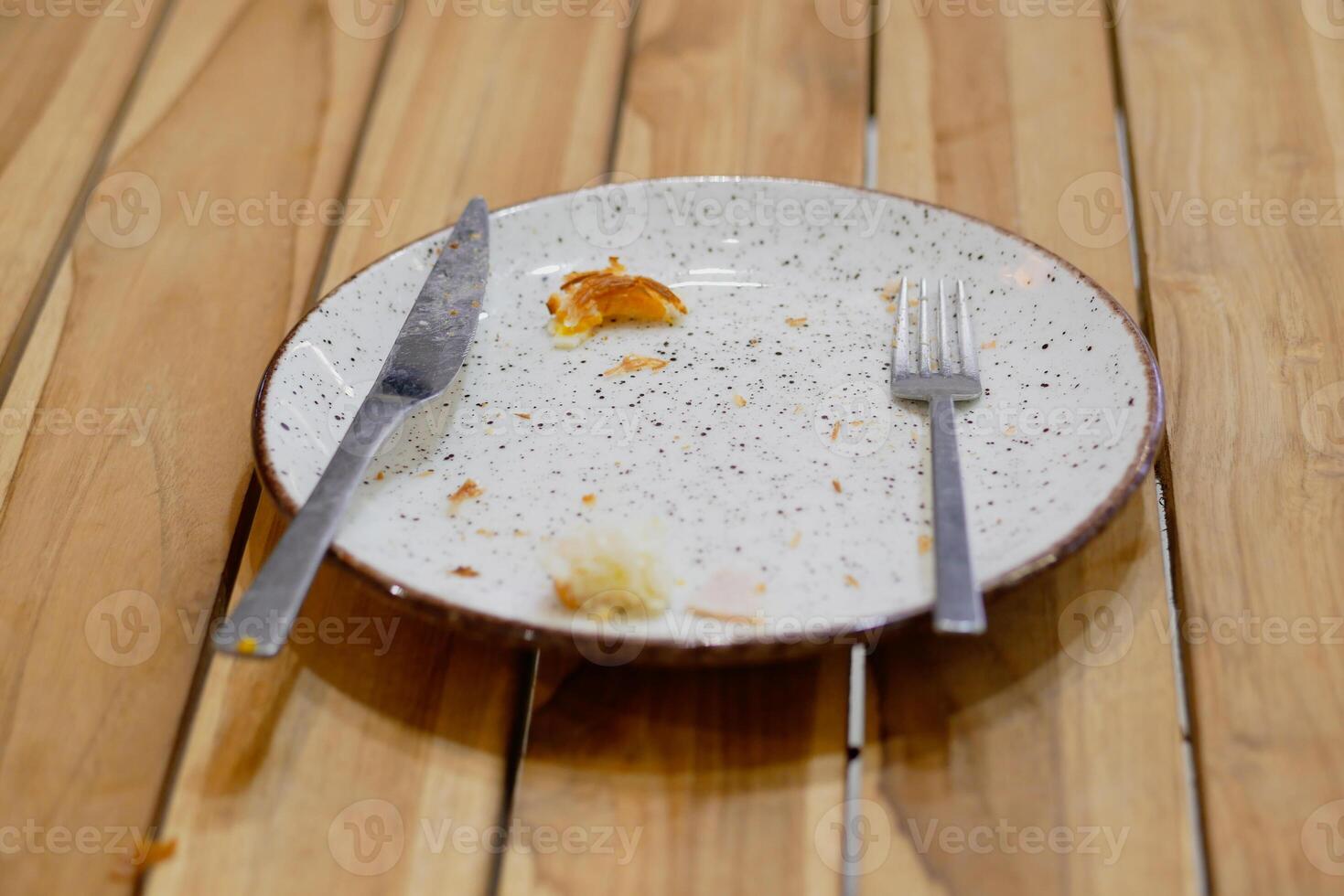 An empty dirty plate with a fork. photo