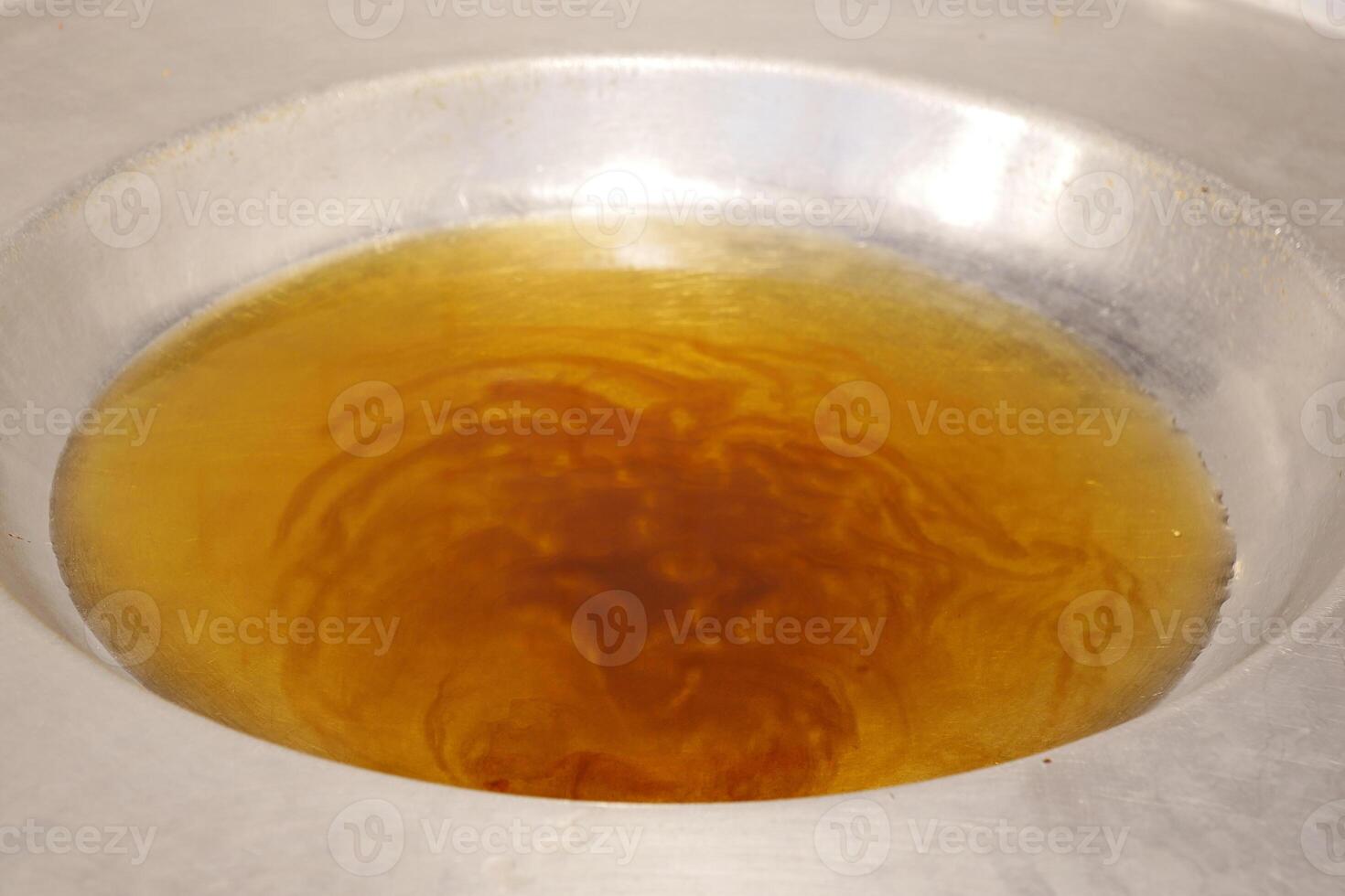 pours vegetable oil into a large frying pan photo