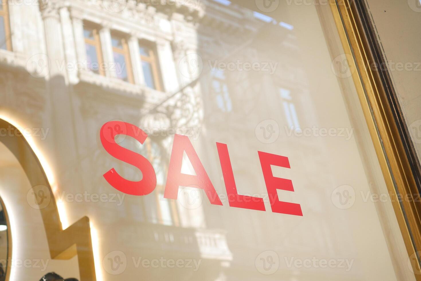 Large red Sale text letters on a glass wall obstruct a view inside the popular fashion store photo