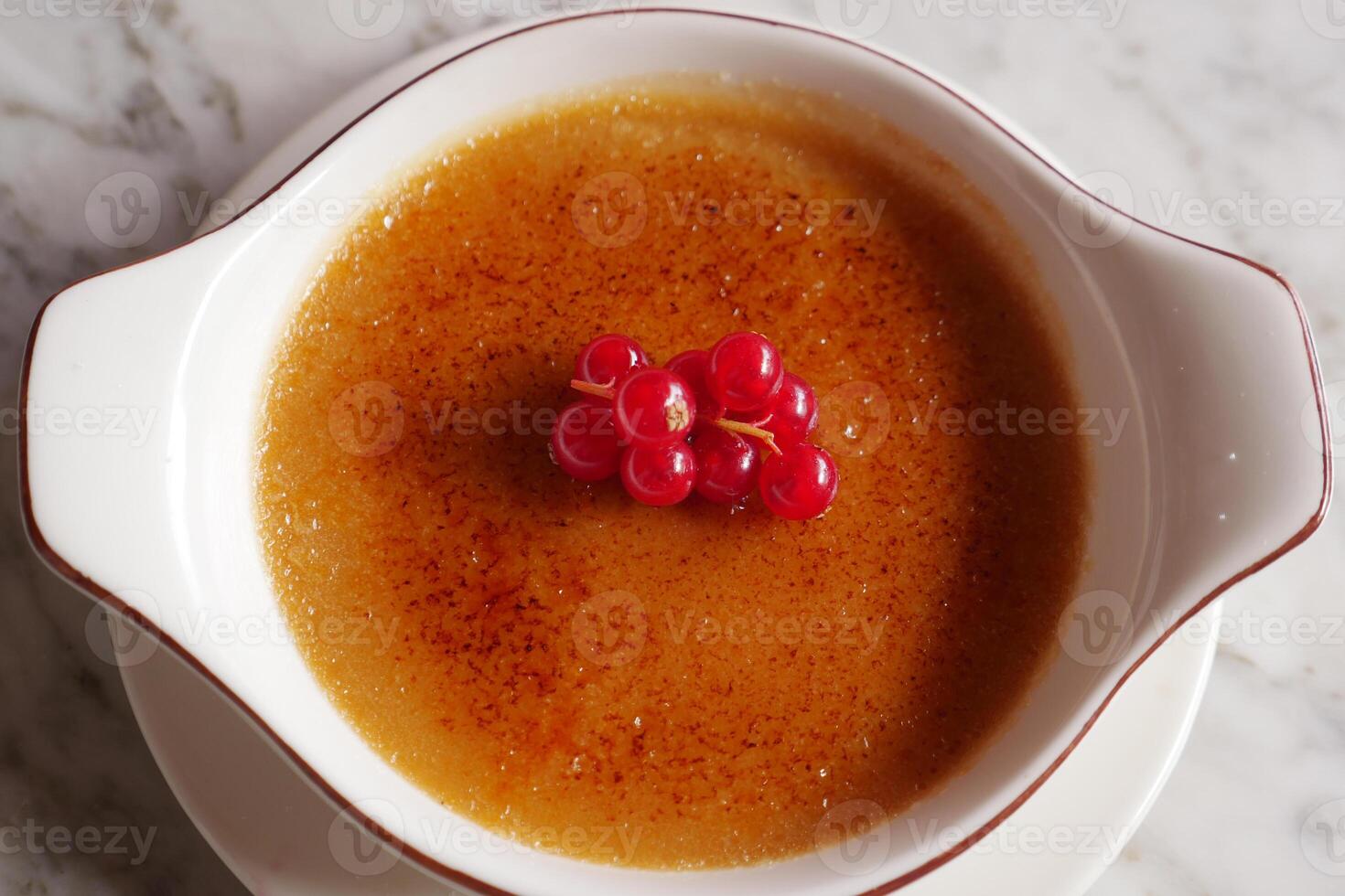 Caramel custard pudding on a plate on table photo