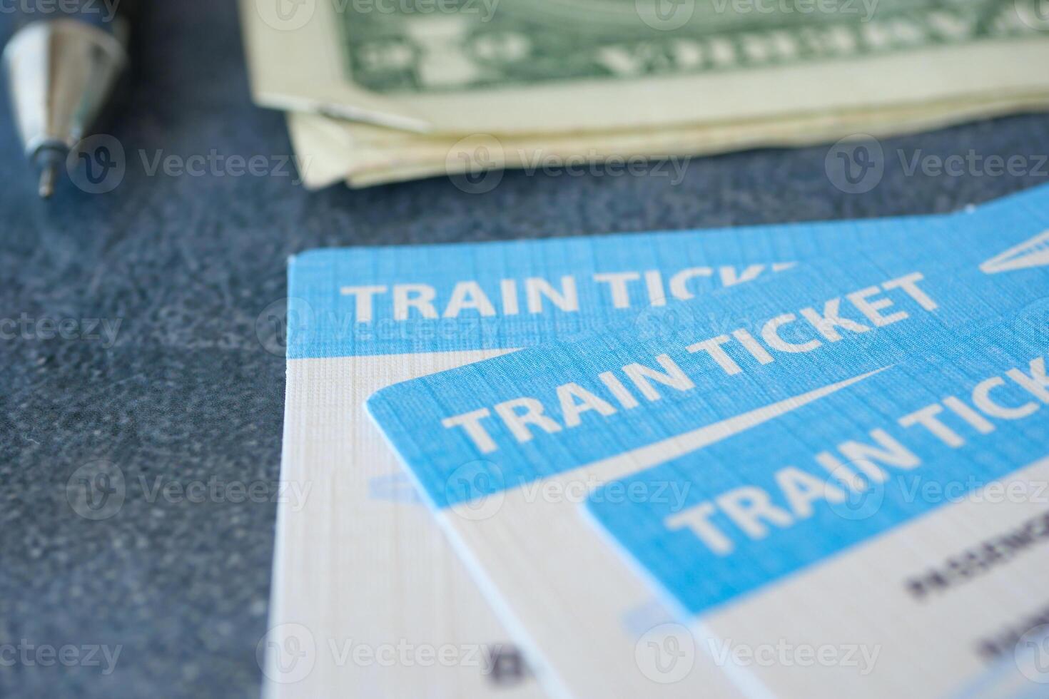 An assortment of train tickets and currency are placed on the table along with a pen photo