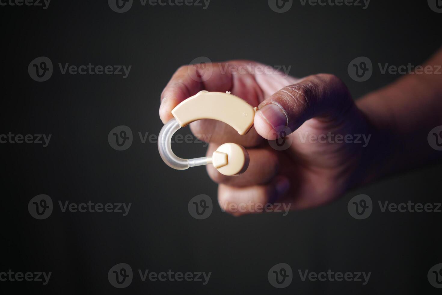 A Hand Holding a Hearing Aid Device for Improved and Enhanced Auditory Assistance Needs photo