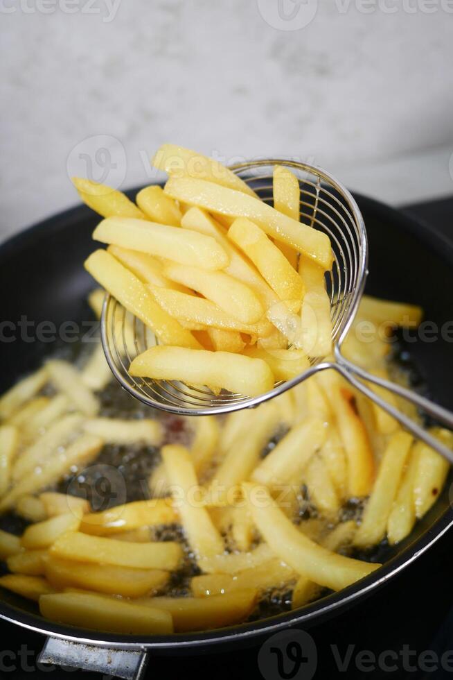 Crispy and Golden French Fries Being Deep Fried to Perfection for a Delicious Snack photo