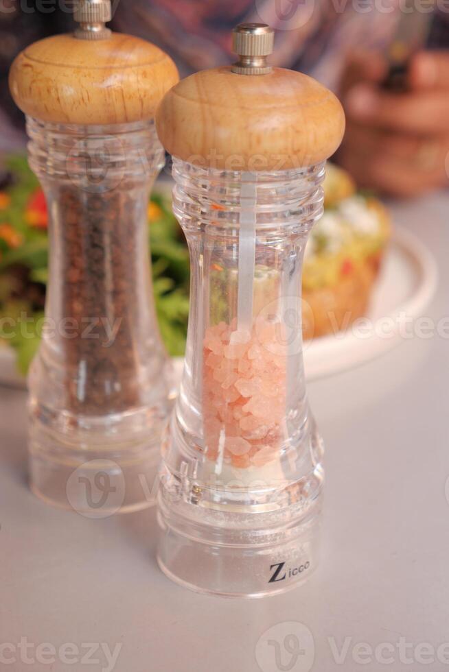 Essential Seasonings Salt and Pepper Grinders Beautifully Placed on a Dining Table Setting photo