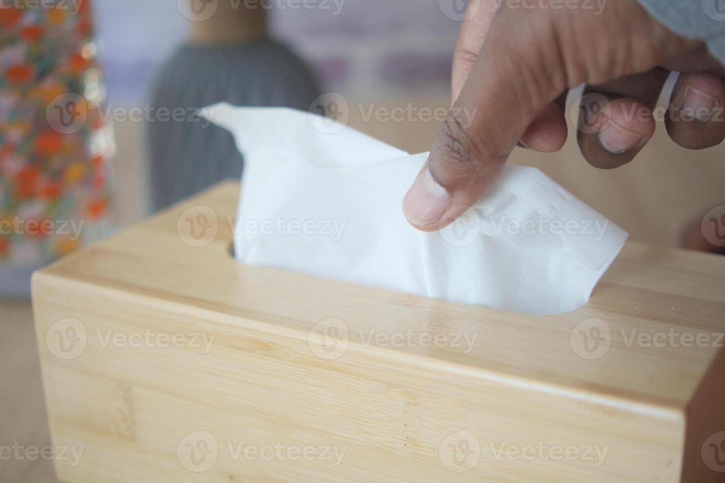 hand pull out a piece of tissue from tissue paper box photo