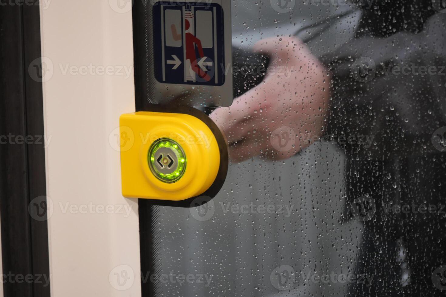 finger presses button to open doors in subway car. photo