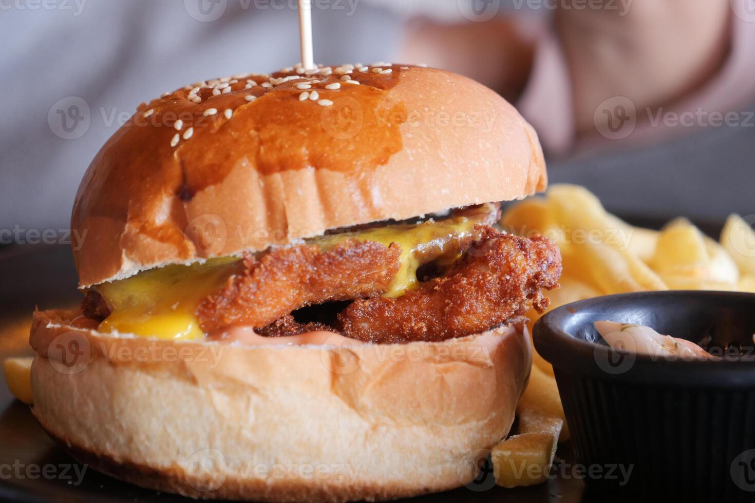 Indulge in a Delicious Fried Chicken Burger topped with melting Cheese and crispy Fries photo