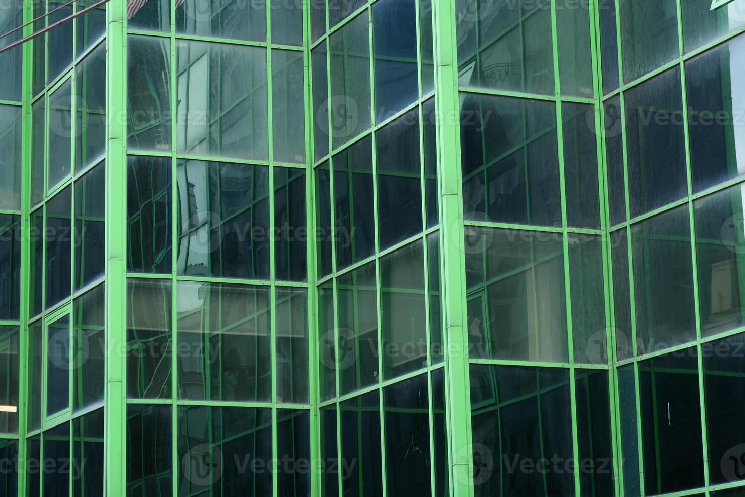 A Modern Green Glass Building Facade Featuring Striking and Intricate Geometric Patterns photo