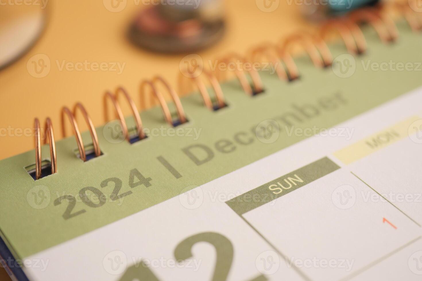 The December 2024 Calendar features a Pen and Coins on a vibrant Yellow Background photo